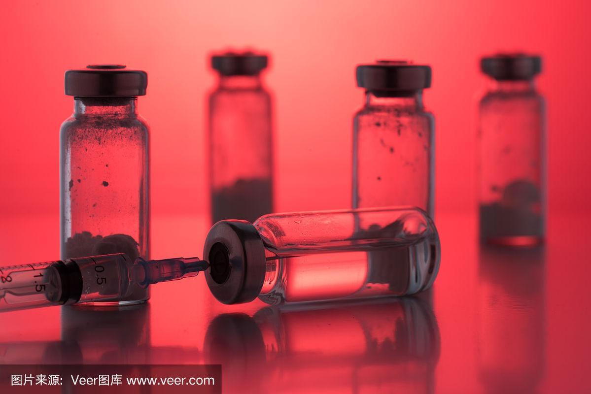 紅色背景上帶一次性塑料注射器的抗生素注射瓶